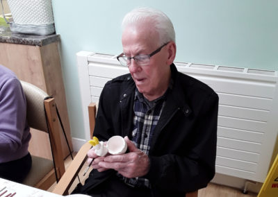 Gentleman resident at Lulworth House painting a rabbit shapes egg cup