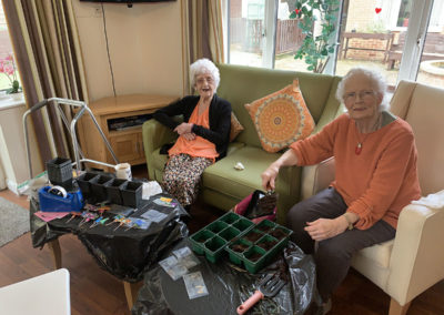 Two ladies at Lulworth House Residential Care Home potting flower seeds