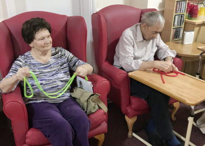 Residents at Lulworth House looking at different coloured bands during an active armchair exercise session