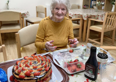 Lady resident decorating a fruit flan