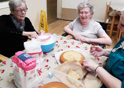 Ladies baking group putting the finishing touches to a Victoria sponge at Lulworth House