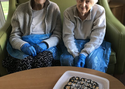 Two lady residents at Lulworth House showing off their decorated chocolate cake