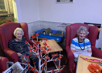 Lulworth ladies sitting together making red Chinese New Year decorations