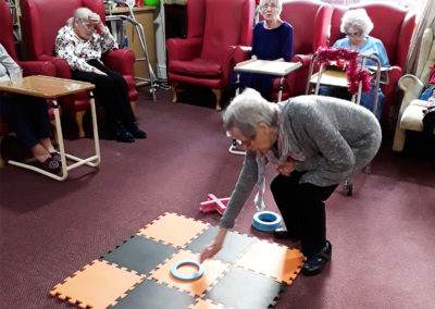 A lady resident placing a piece down on a giant noughts and crosses board