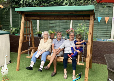 Residents and family in the garden on the swing chair