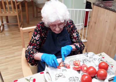 Lady resident cutting up tomatoes for soup