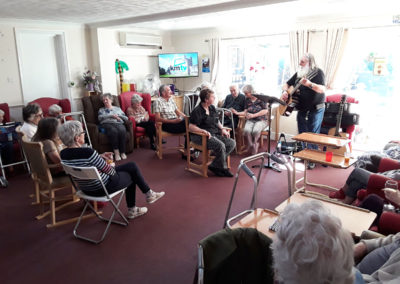 Residents being entertained by a singer in their lounge