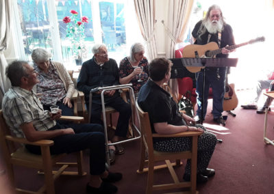 Residents being entertained by an entertainer in their lounge
