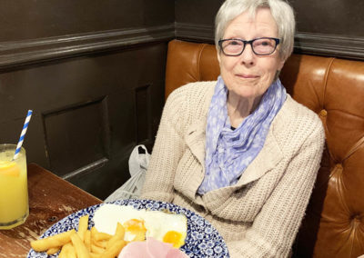 Lady resident with a huge lunch plate of ham, egg and chips
