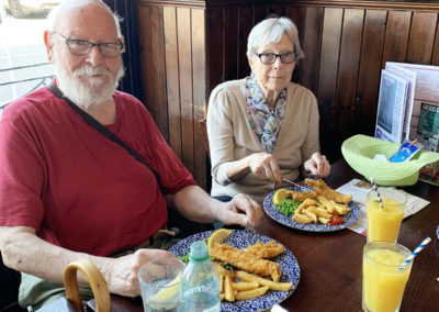 Two residents sitting together in a pub eating fish and chips