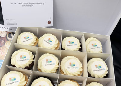 A box of cupcakes with interactiveMe logos on
