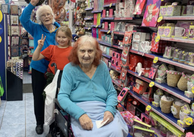 Two residents and a young relative in a gift shop by the shelves