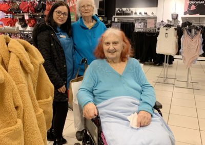 Two residents and a staff member in a clothing shop