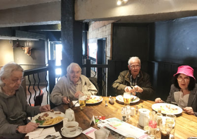 A group of residents around a table enjoying lunch at the pub