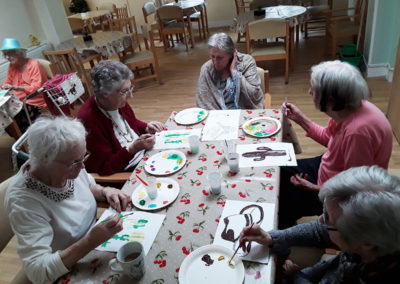 A table of residents painting Country and Western pictures