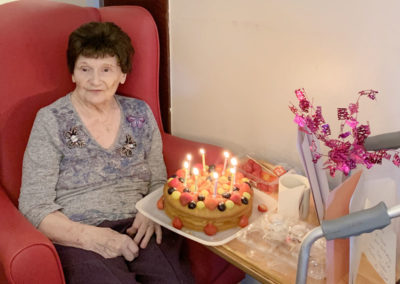 Lady resident receiving a fruit decorated birthday cake