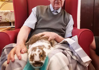 Male resident with rabbit on lap