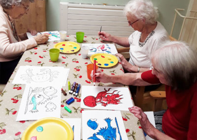 Lady residents painting together sat at a table at Lulworth House