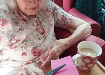 Lady resident cutting out crafts materials at Lulworth House Residential Care Home
