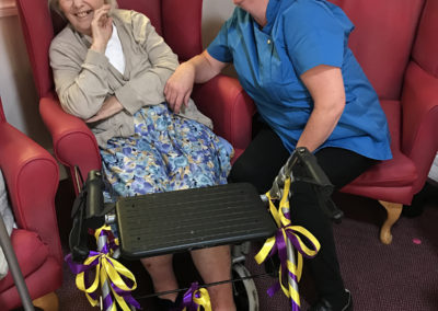 A staff member and lady resident with her decorated zimmer frame at Lulworth House