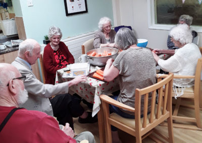 Residents preparing vegetables around a table together at Lulworth House