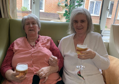 Two Lulworth House ladies smiling with a fizzy drink during a pub afternoon