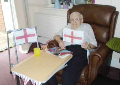 Seated male resident with a hand made England flags