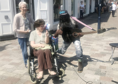 Residents listening to a busker in a town centre