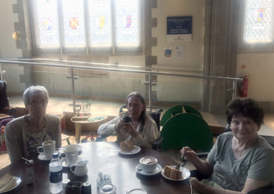 Seated residents enjoying coffee and cake together in the Maidstone museum