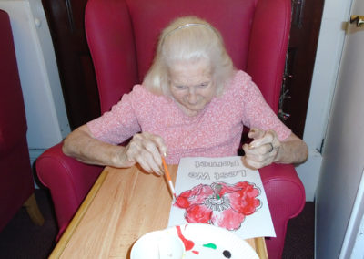 Lulworth House resident painting a poppy picture