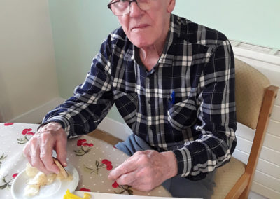 Male resident sitting at a table with a spring crafts picture