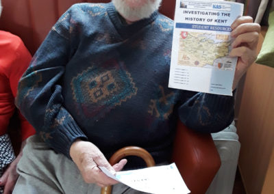 Resident with historical sheet of information during a History Club