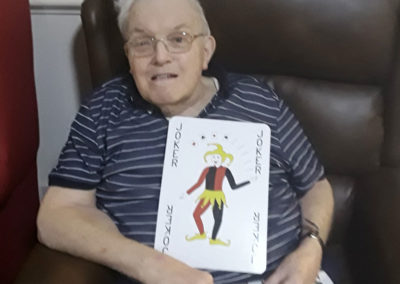 Gentleman holding a giant playing card at Lulworth House Residential Care Home