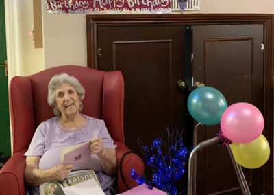 Lady celebrating her birthday with decorations, presents and balloons at Lulworth House Residential Care Home
