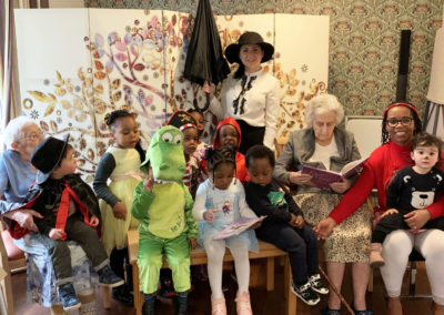 Nursery children in fancy dress and residents posed for a photo together on World Book Day