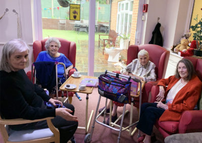 Four lady residents at Lulworth House, smiling to the camera on World Book Day