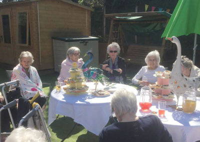 Lulworth House residents enjoying a tea party in the garden together