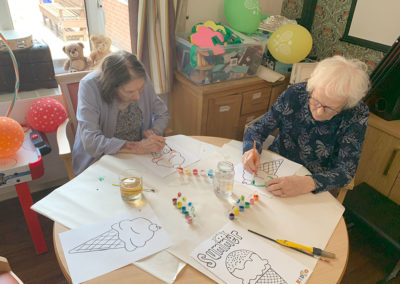 Two Lulworth House ladies using watercolours to paint pictures of ice creams