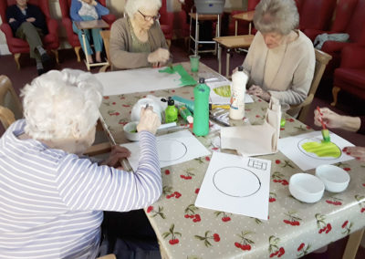 Residents painting tennis ball pictures in preparation for a Wimbledon party