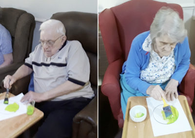 Residents painting tennis ball pictures in preparation for a party