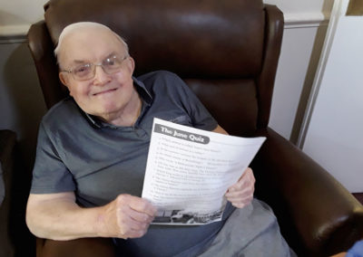 Resident holding a quiz sheet at Lulworth House Residential Care Home