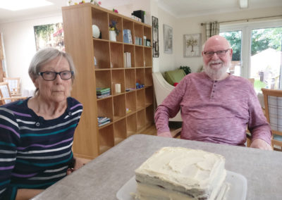 Two residents with an iced cake they are working on