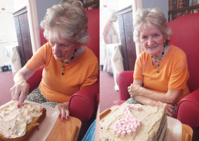 Lady resident decorating a birthday cake with a musical note