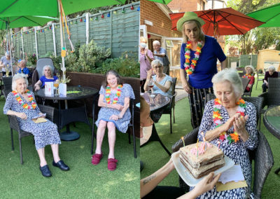 Residents in the garden and a lady residents being presented with a birthday cake