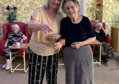 Two lady residents smiling at the camera together at Lulworth House Residential Care Home