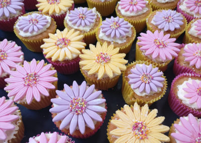 A tray of flower design cupcakes